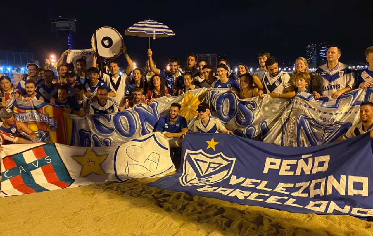 La peña en la playa con sus banderas